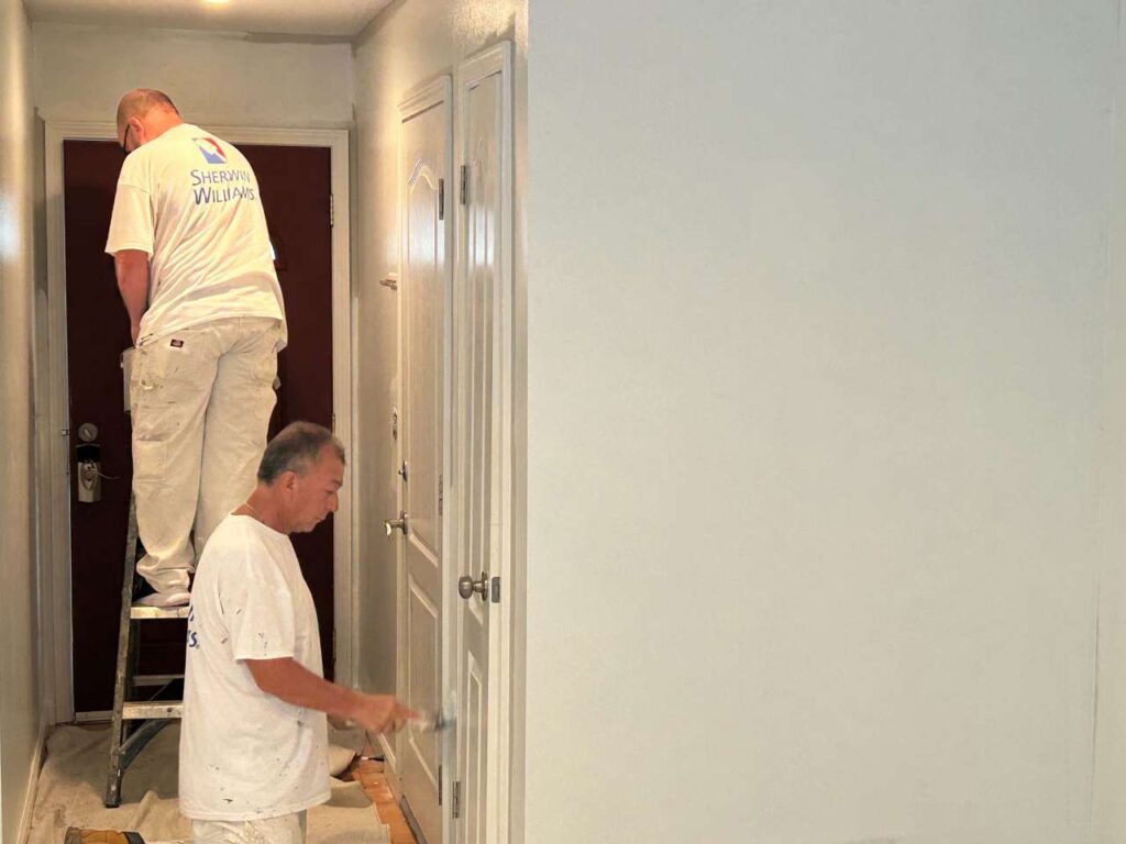 A close-up, high-resolution photograph showcasing a skilled hand expertly wielding a paint roller.