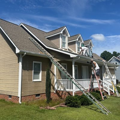 A house with freshly painted tan siding and white trim.